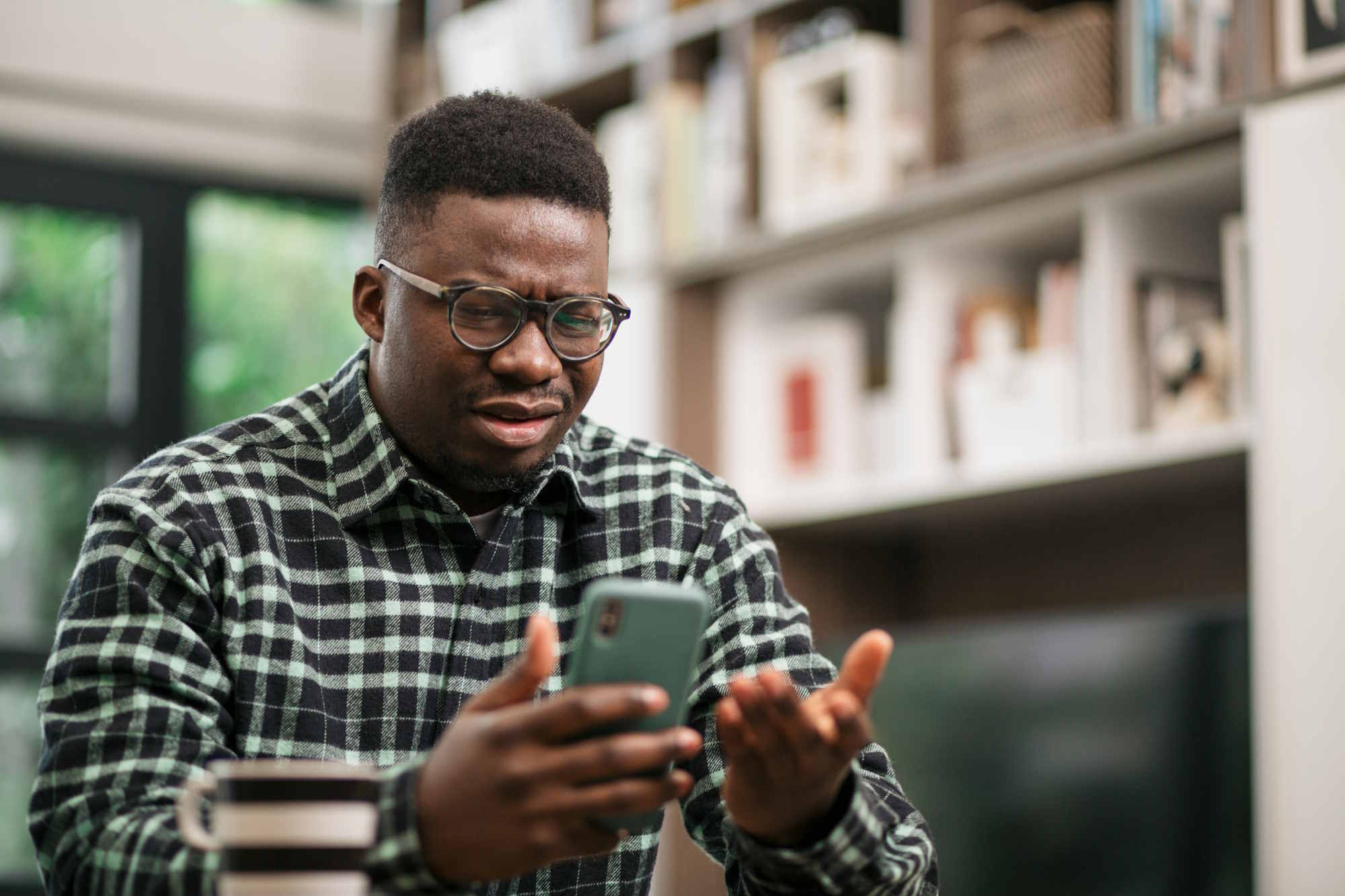 Image d'illustration représentant un jeune homme apparemment déboussolé devant son téléphone