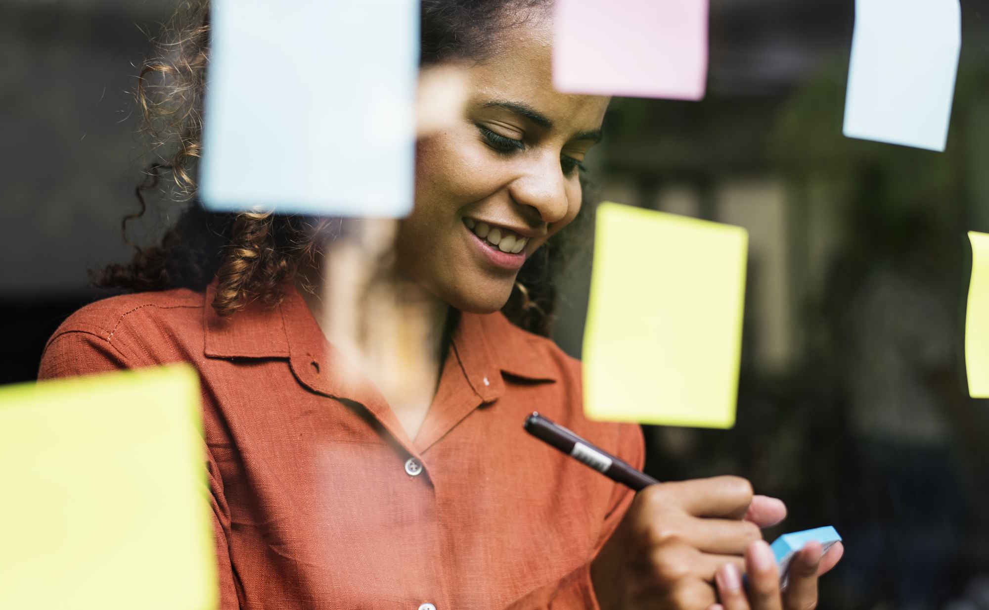 Photo d'une femme organisant ses notes sur des post-its