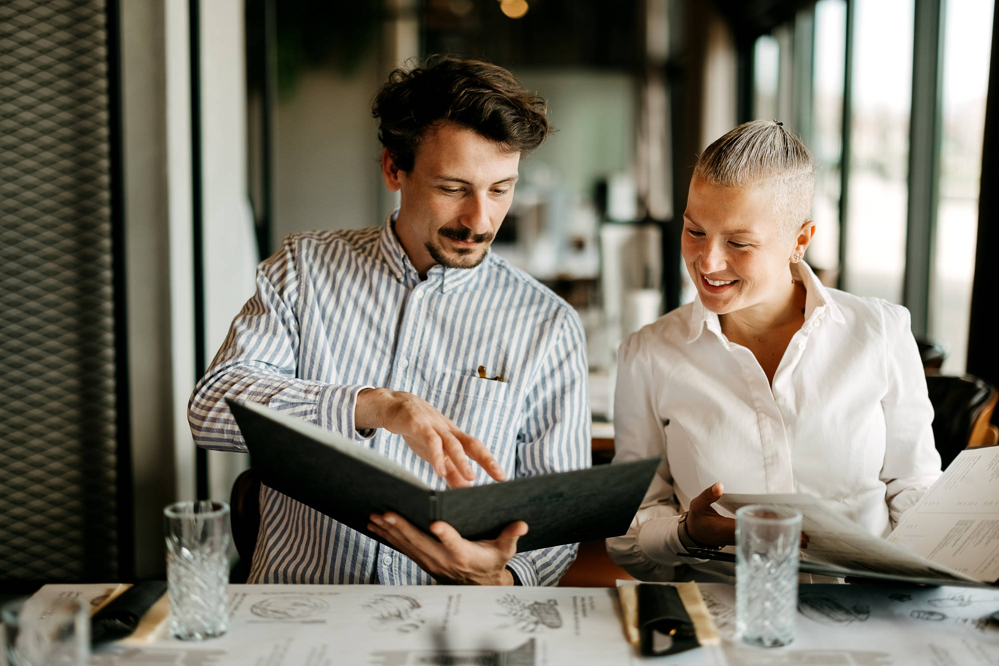 Photo d'illustration de deux personnes qui lisent le menu dans un restaurant
